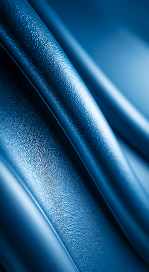 Abstract textured curves centered on a deep blue background with tactile grain and sleek metallic sheen, ultra hd