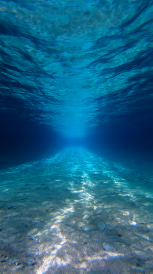 Minimalist underwater sunlit seabed on turquoise tones with rippled light caustics ultra HD 8K background image.
