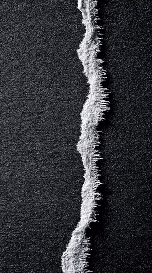 Minimalist torn paper edge centered on a black textured background in a stark monochrome aesthetic, ultra HD image