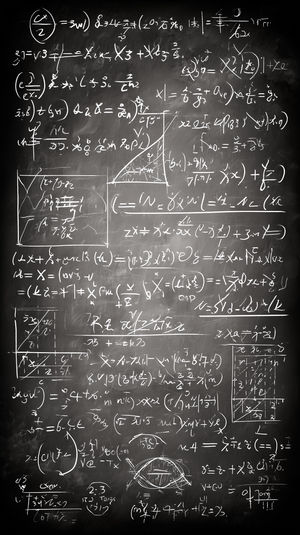 Vertical chalkboard filled with dense handwritten math equations, diagrams, and sketches in white chalk on a dark textured background.