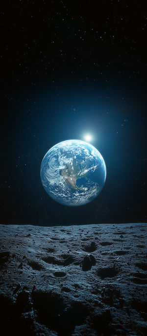 Moon's rugged surface foreground with Earth rising above the horizon against a star-filled dark space backdrop.