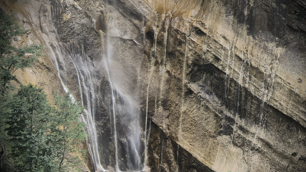 Una cascata che scende sulla parete di roccia ocra lungo le cascate del Ruzzo