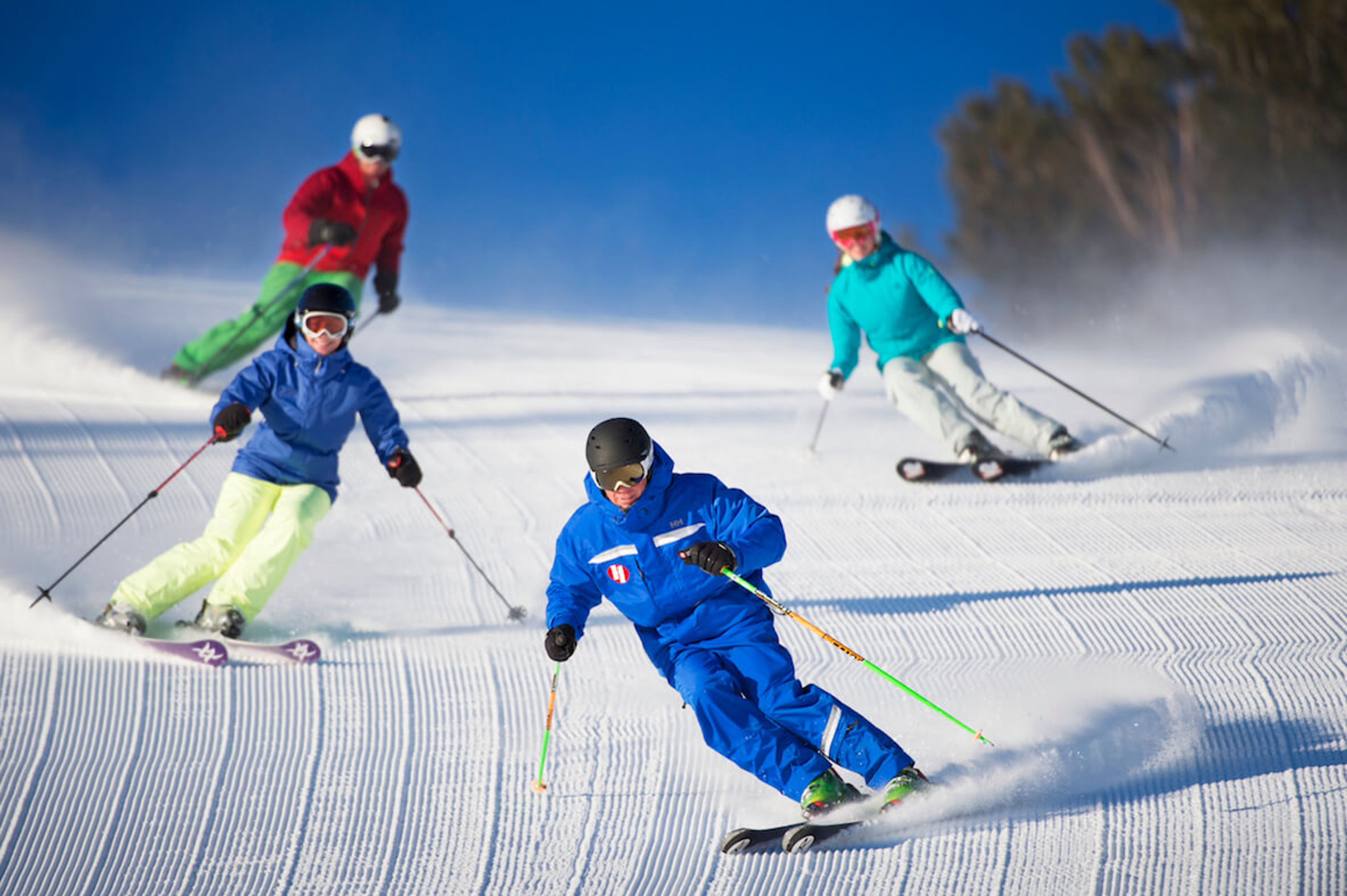 Group of people skiing on a groomed run