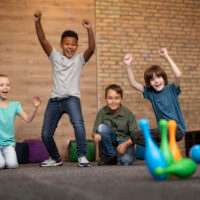 full-shot-smiley-kids-playing-bowling
