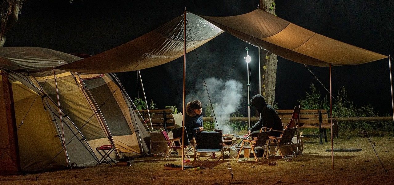 2 people under tent awning