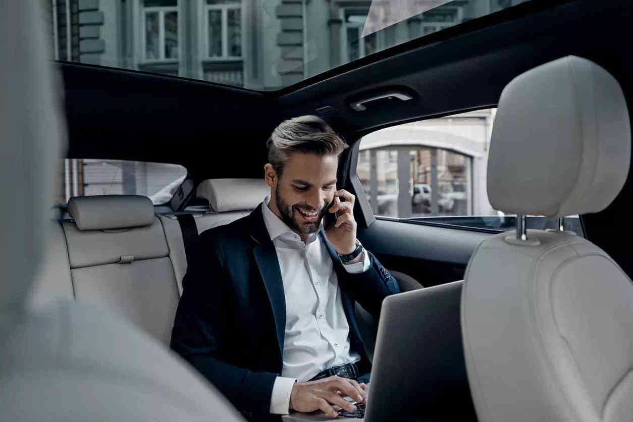 Chauffeur professionnel ALOTRANSPORT en uniforme devant véhicule premium
