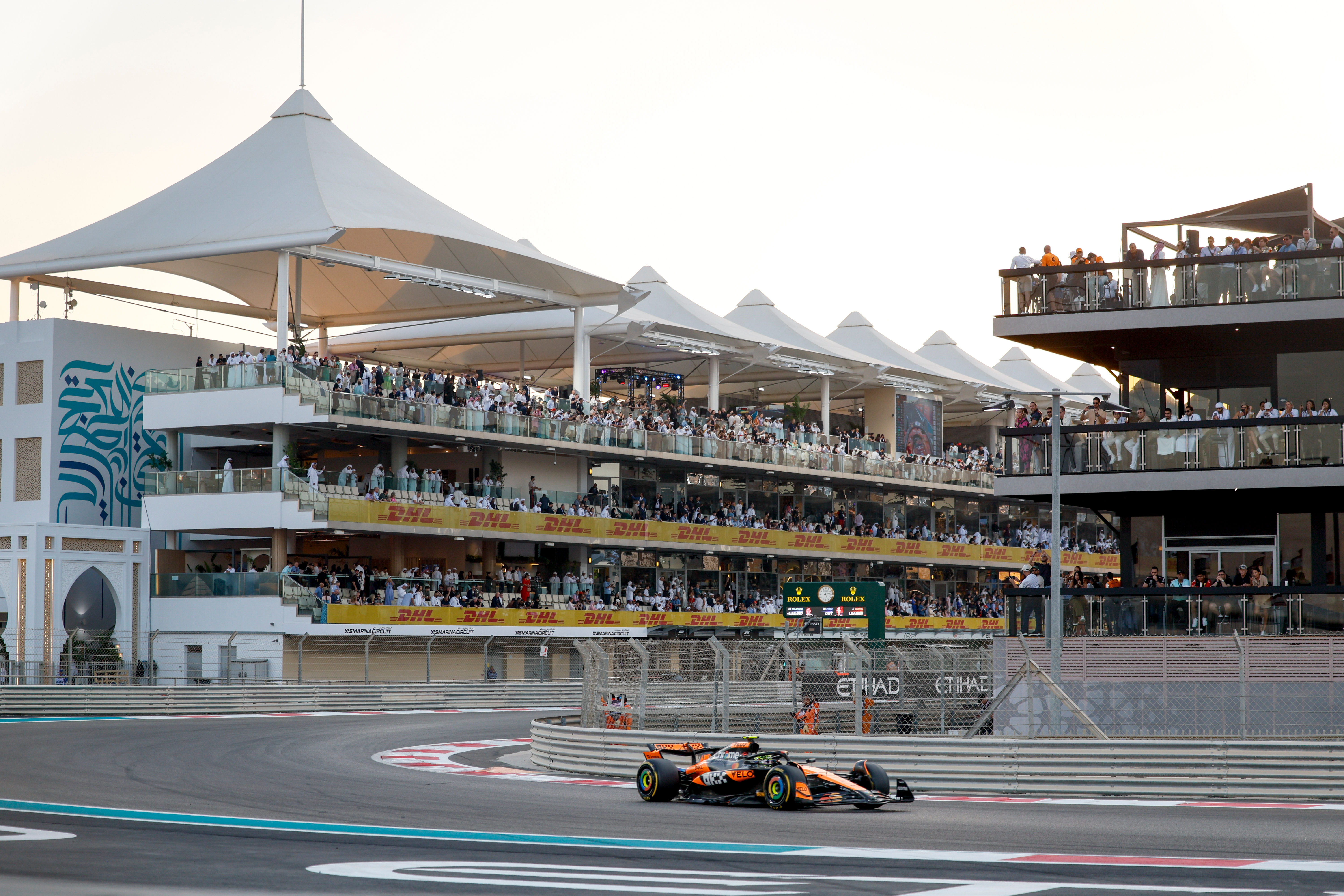 A McLaren car taking on the first corner of Yas Marina Circuit
