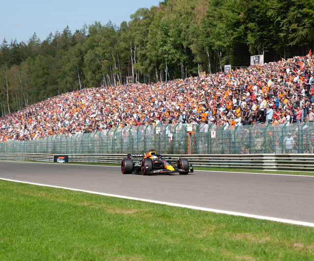 Un coche de Fórmula 1 de Red Bull pasa por delante de una tribuna llena de aficionados a la Fórmula 1