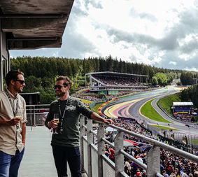 Guests enjoying a glass of Champagne on the balcony of the Gold 2 VIP Lounge