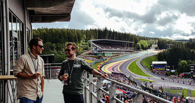 Guests enjoying a glass of Champagne on the balcony of the Gold 2 VIP Lounge