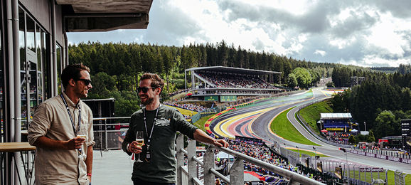 Guests enjoying a glass of Champagne on the balcony of the Gold 2 VIP Lounge