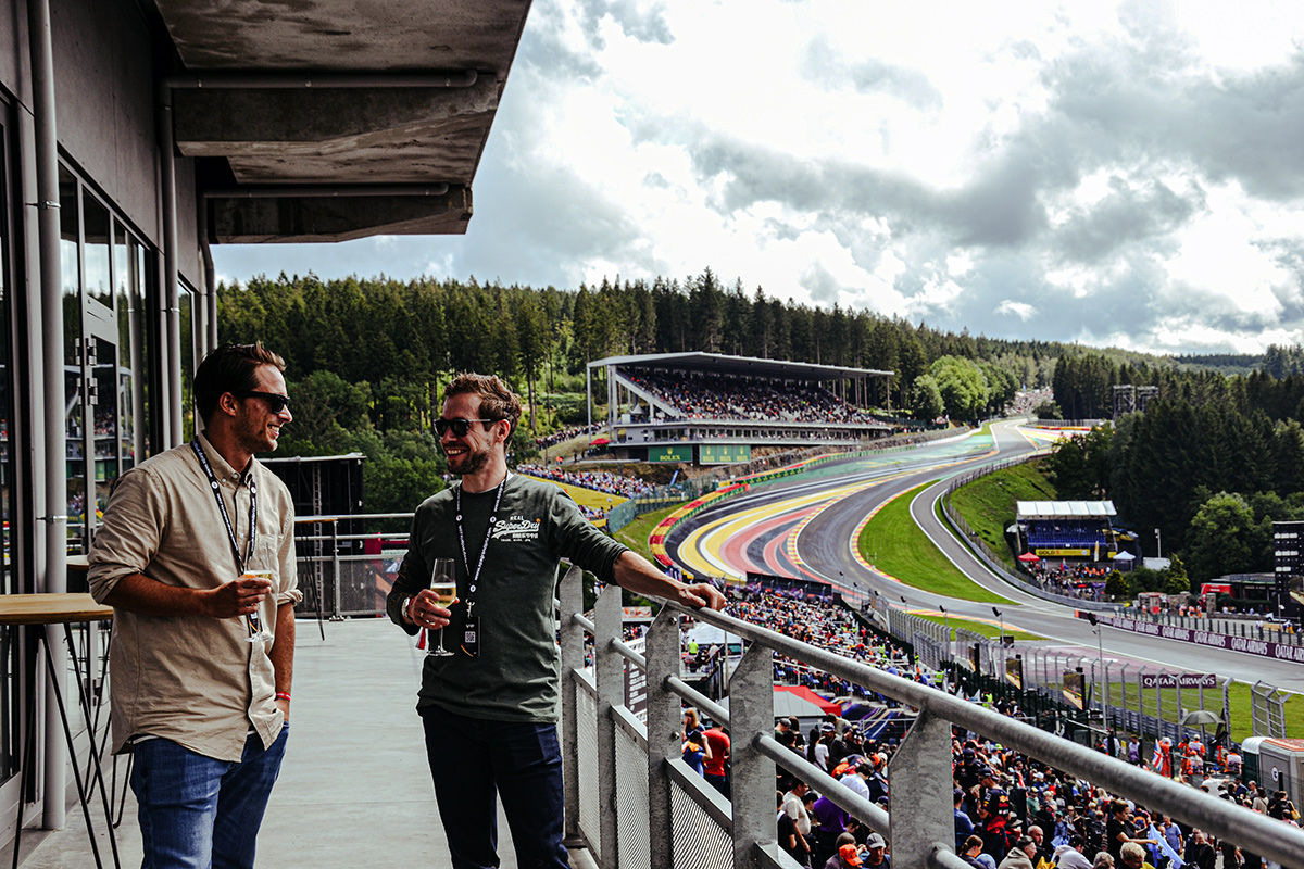 Guests enjoying a glass of Champagne on the balcony of the Gold 2 VIP Lounge