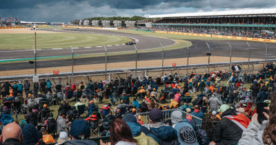 An F1 car in the Chapel-corner while fans are watching from the grandstand