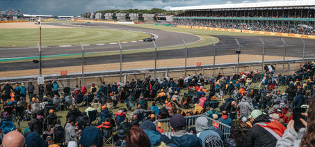 An F1 car in the Chapel-corner while fans are watching from the grandstand