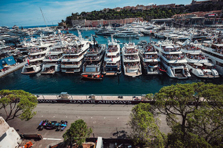 Alpine F1 car driving past the yachts in the harbor of Monaco