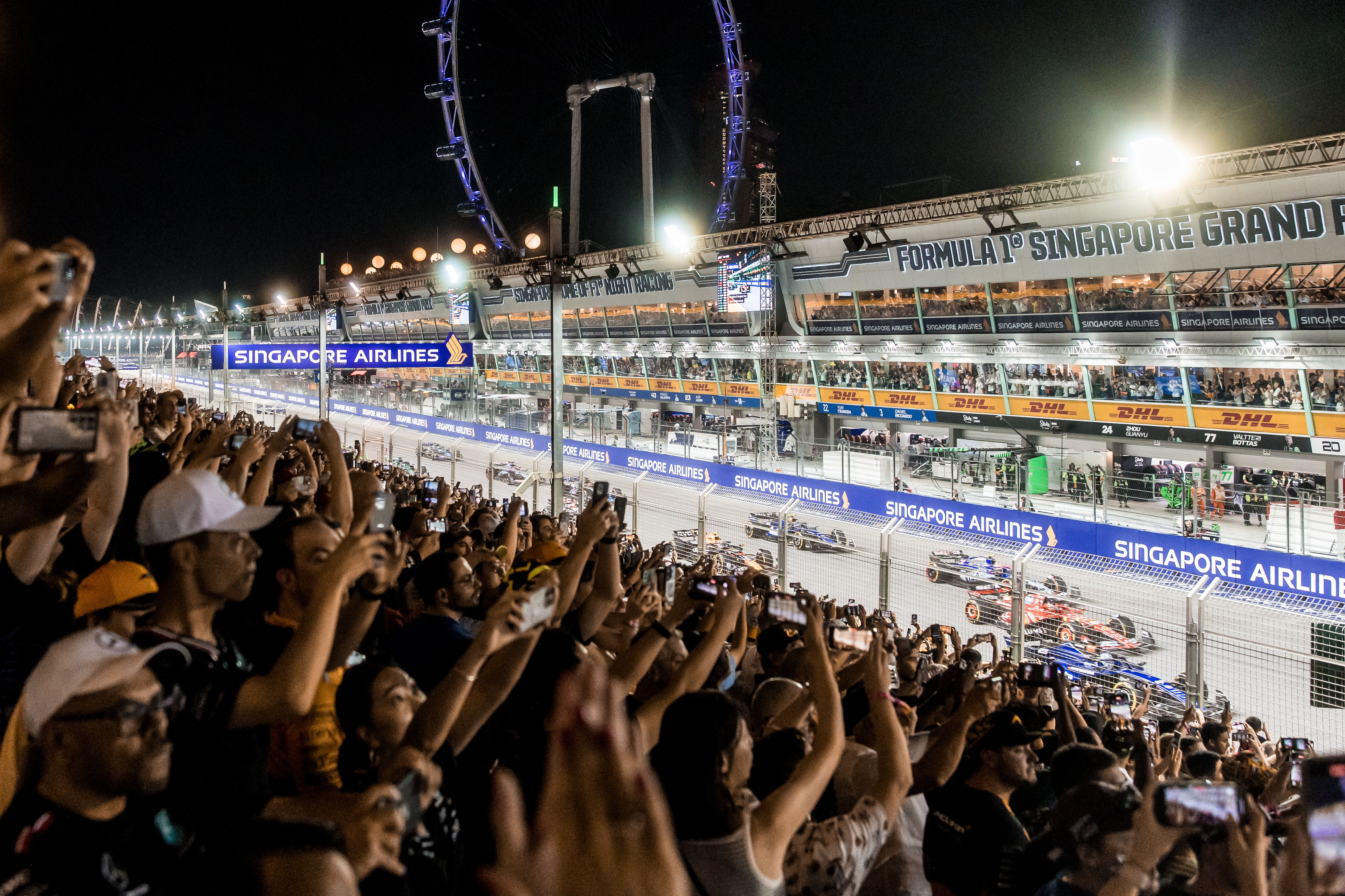 The F1 cars drive past the Pit Grandstand during the start of the Singapore GP