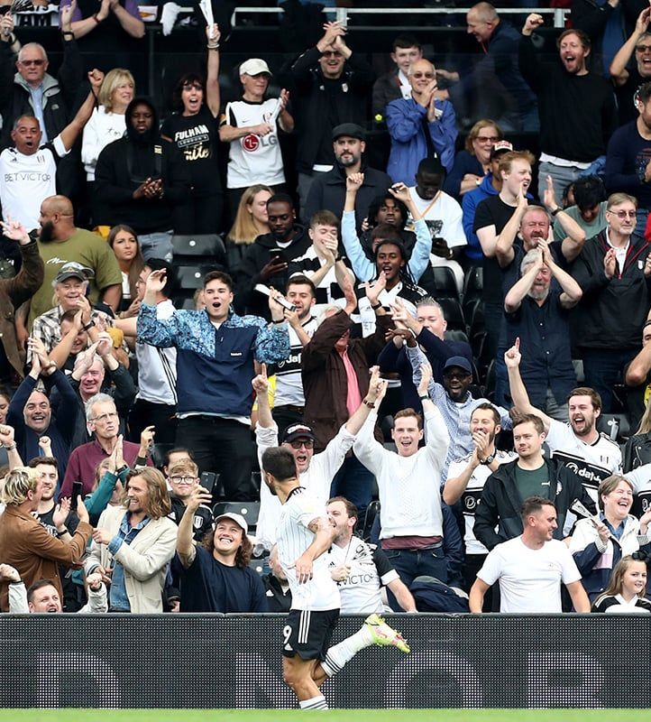 Fulham supporters cheering for a player during a match