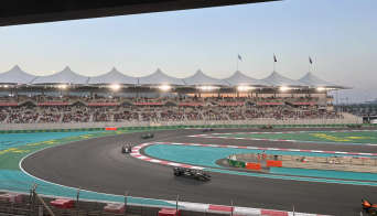 F1 cars driving past the grandstand that comes with the North Yas Suite Premium package