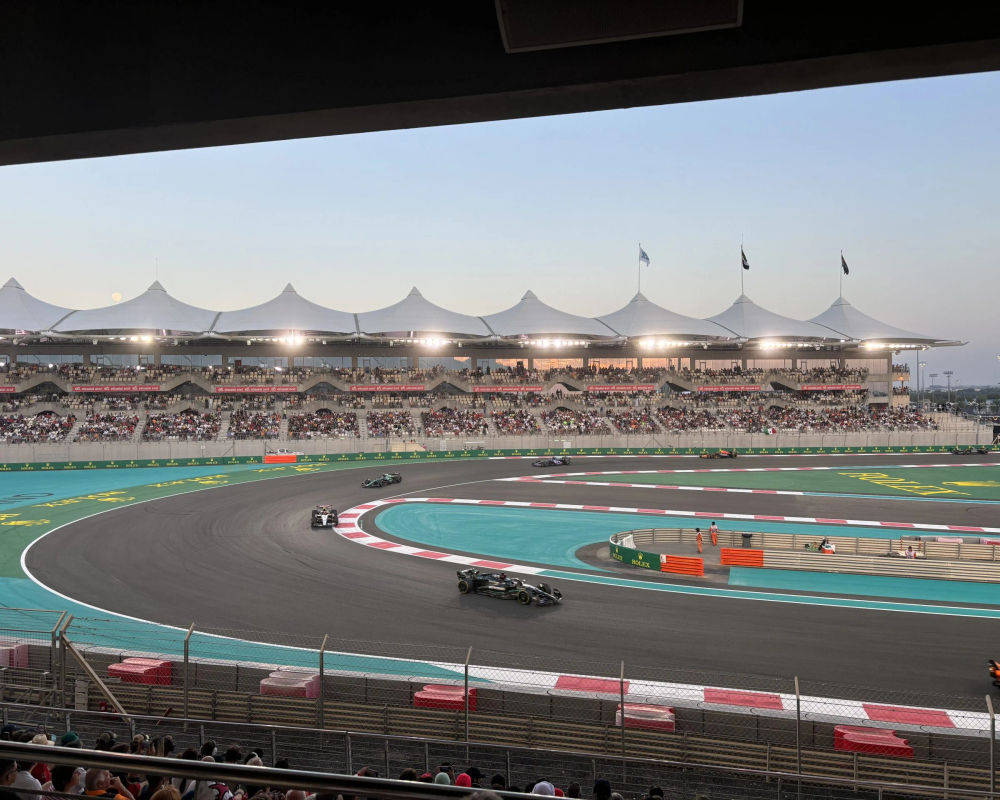 F1 cars driving past the grandstand that comes with the North Yas Suite Premium package