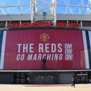 Estadio Old Trafford con el banner « The Reds Go Marching On » del Manchester United
