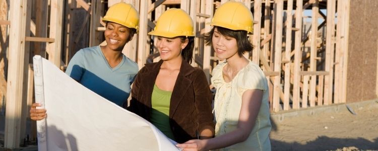 Female construction workers looking over a blueprint