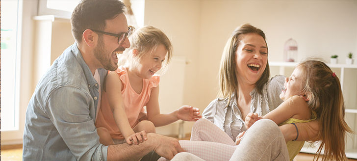 Family of four laughing together