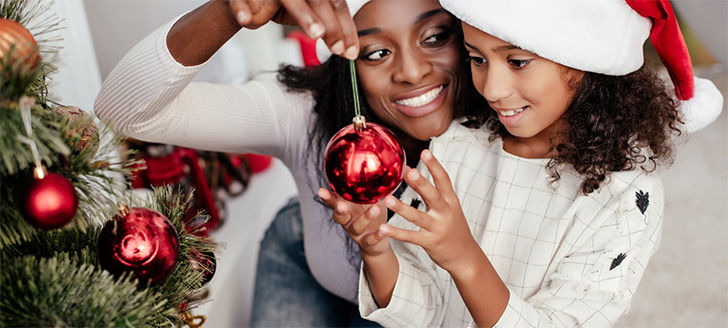 Mother and daughter decorating the Christmas tree