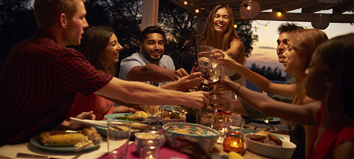 Group of friends having dinner and drinks on a patio together