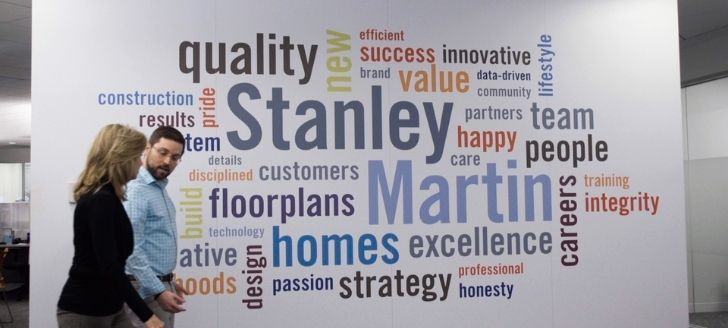 Stanley Martin employees walking in front of the values on the walls at the corporate office