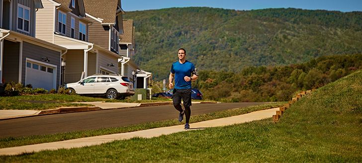 man running on sidewalk in neighborhood