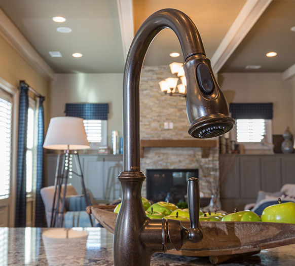 Faucet head with a living room in the background