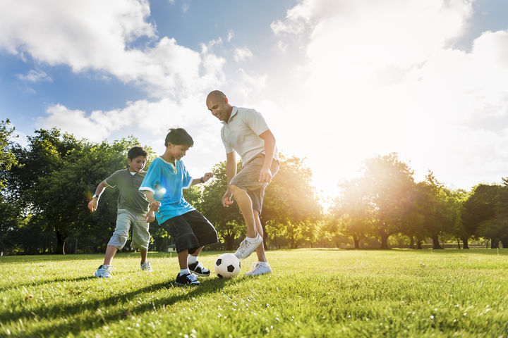 family playing soccer on field