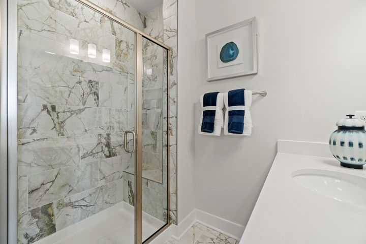 primary bath with glass enclosed shower with seat