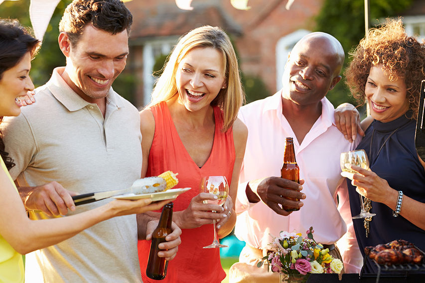 Friends enjoying a BBQ outdoors with drinks