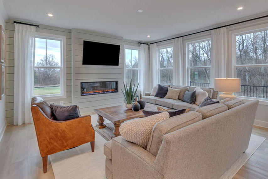 open concept family room kitchen and dining area with bright windows