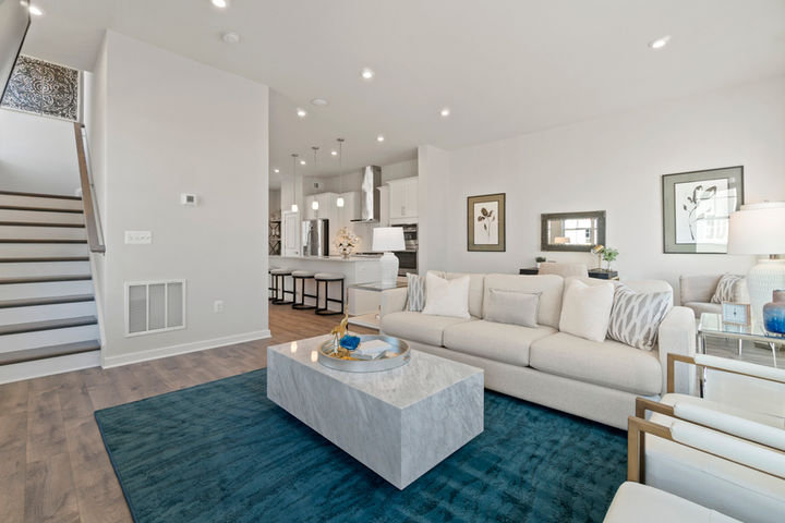 family room in front of stairs and next to open kitchen