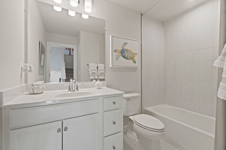 hall bath with cabinet vanity and tub shower