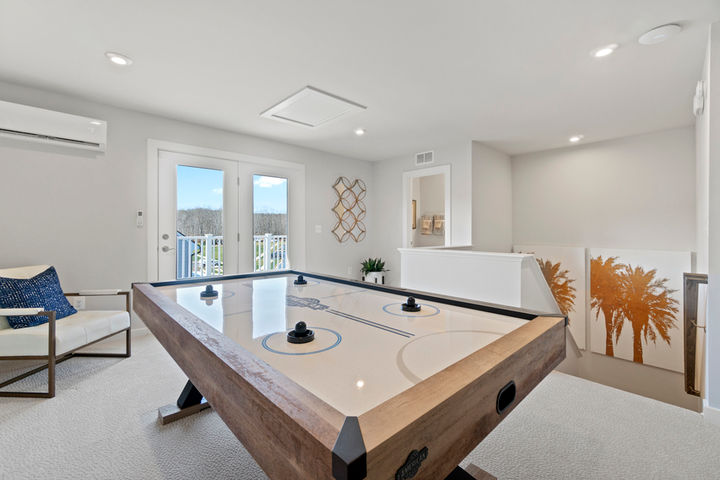 loft with air hockey table and atrium door to terrace