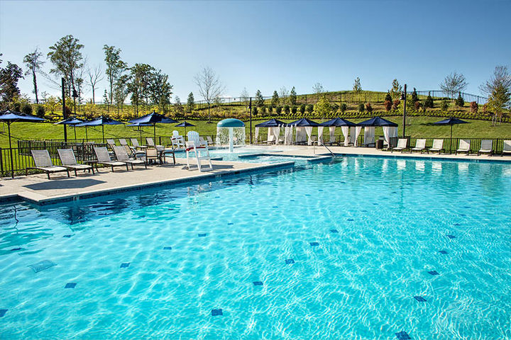 large pool with kids area sundeck with chairs and umbrellas