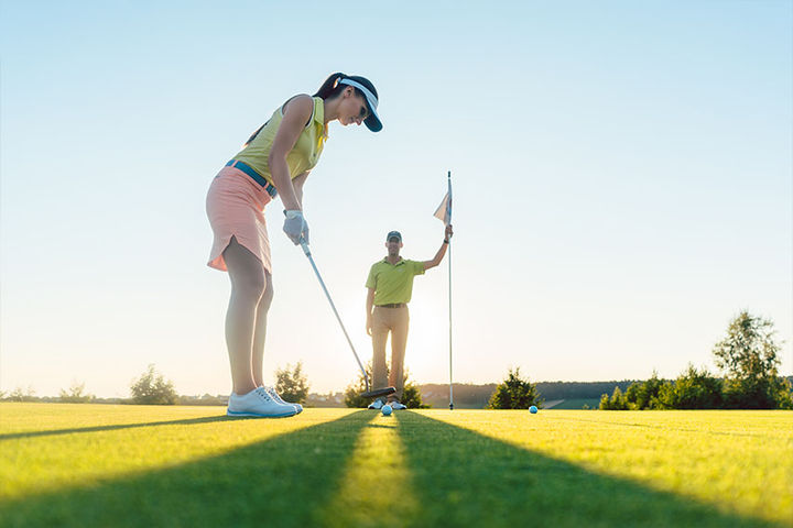 couple playing golf at sunrise