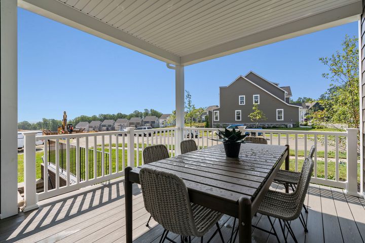 covered porch with table and chairs