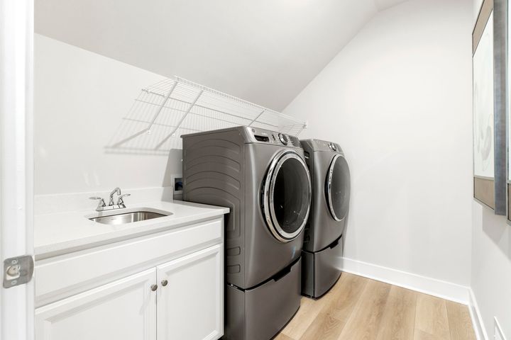 upper level laundry room with sink and shelves