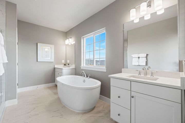 primary bath with dual vanities and stand alone tub