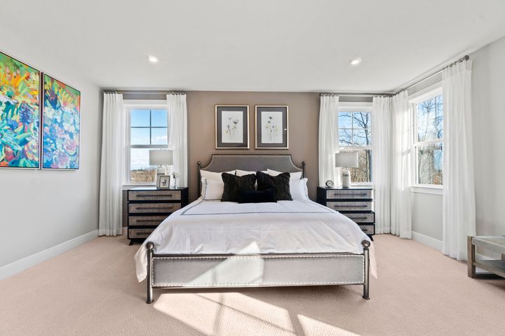 primary bedroom with bed between big windows