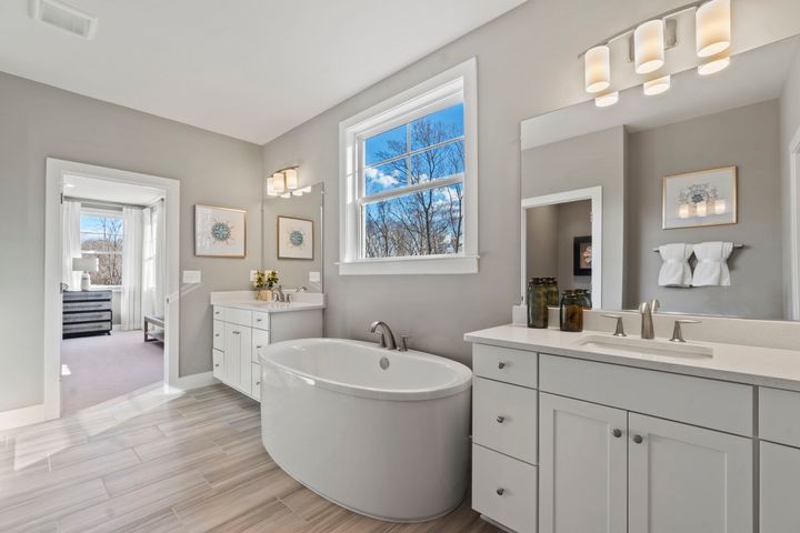 primary bath with stand along tub under window