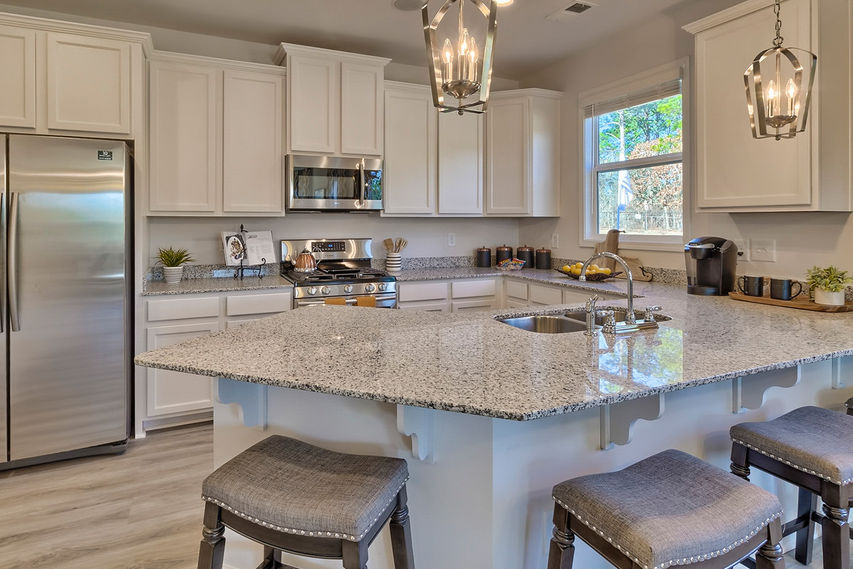 Kitchen with white cabinets and stool seating at island