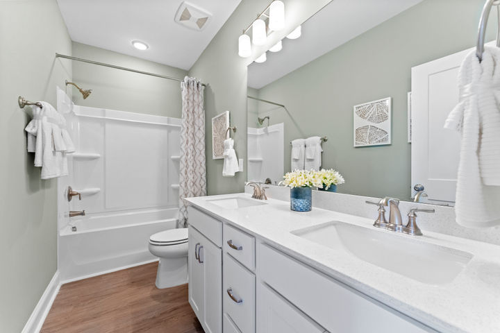 hall bath with dual vanity and tub shower