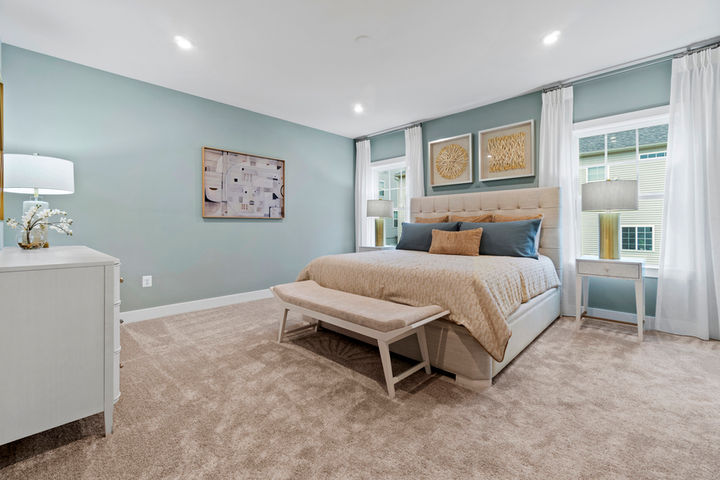 primary bedroom with bed between windows