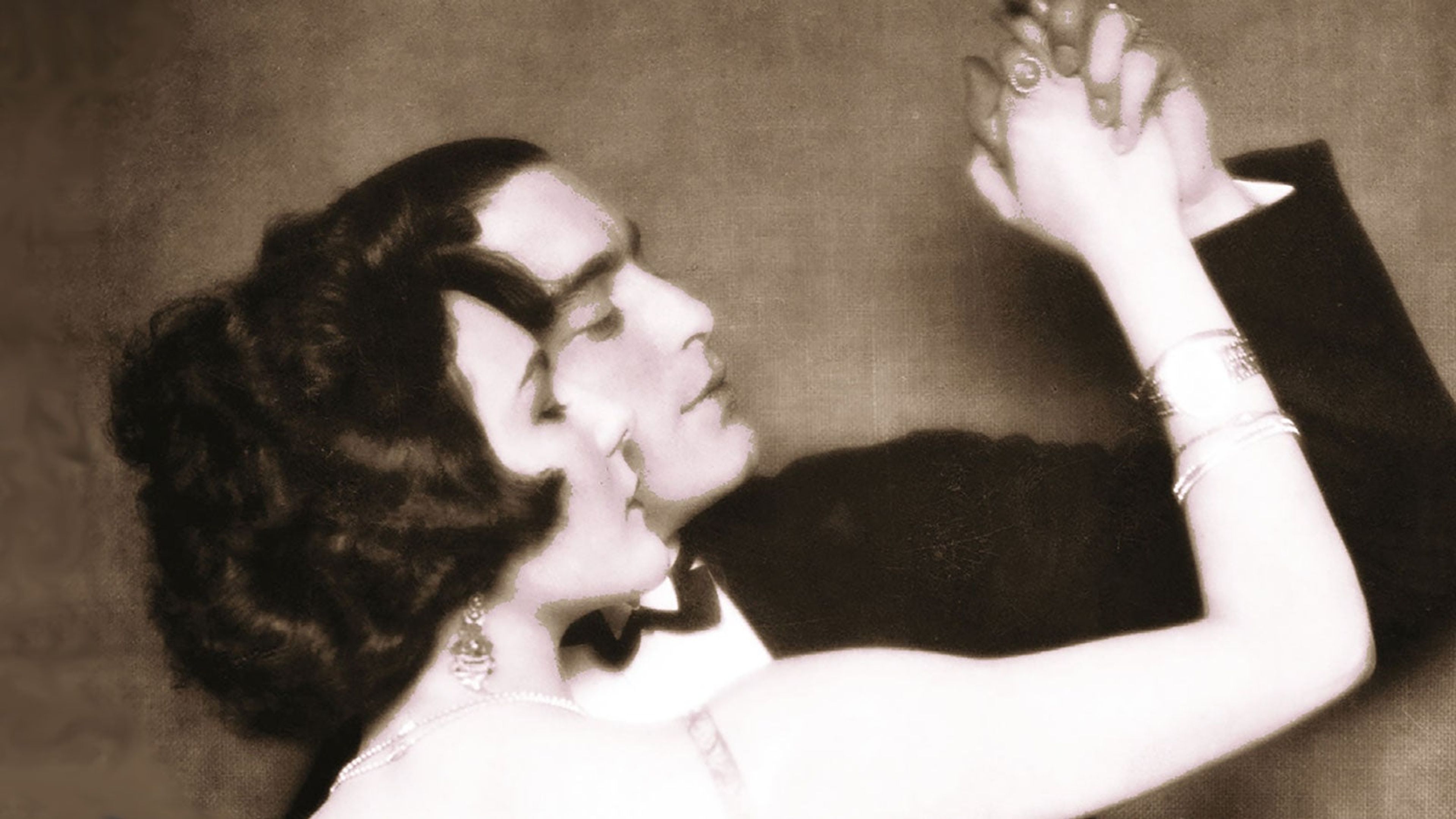 A sepia photograph of a man and woman dancing in 1920s dress