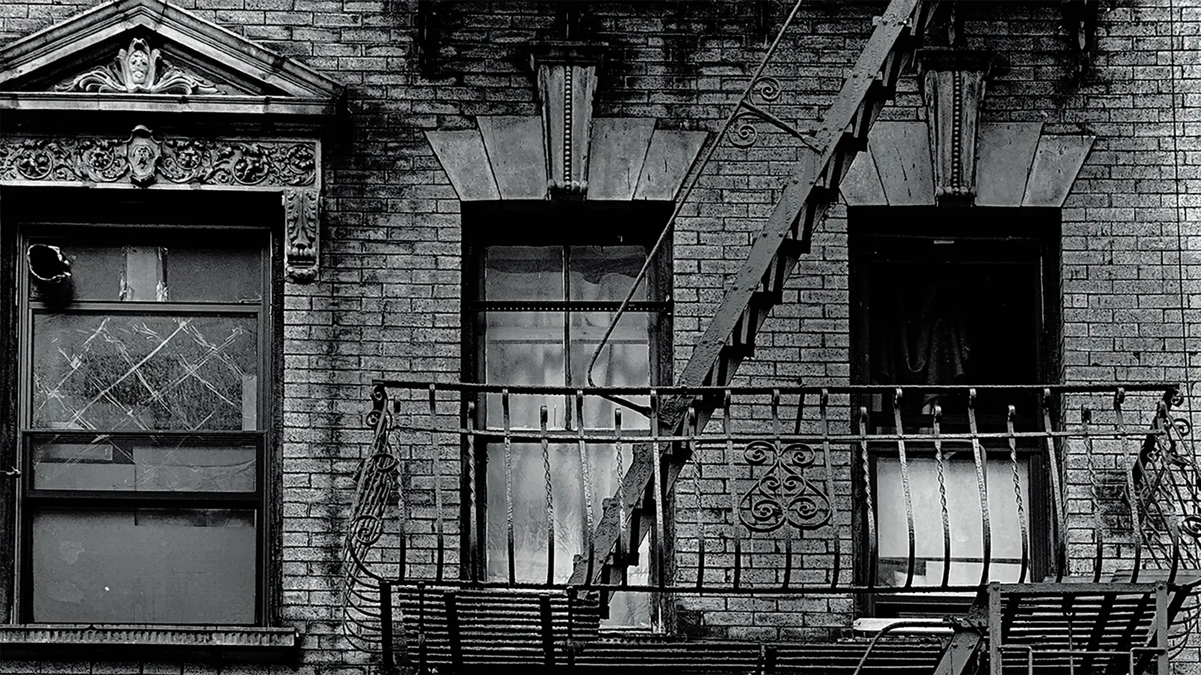 A black and white photograph of the outside of a New York City apartment building